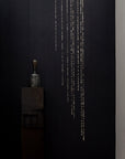 A room with a black wall and a Meystyle Conductivity LED Wallpaper with Swarovski vase glowing with electricity.